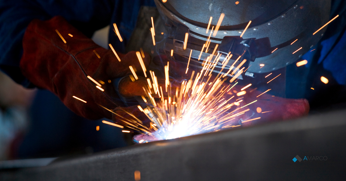 Close-up of intense sparks flying from a welding torch, representing durable processes like heat-welded commercial flooring.
