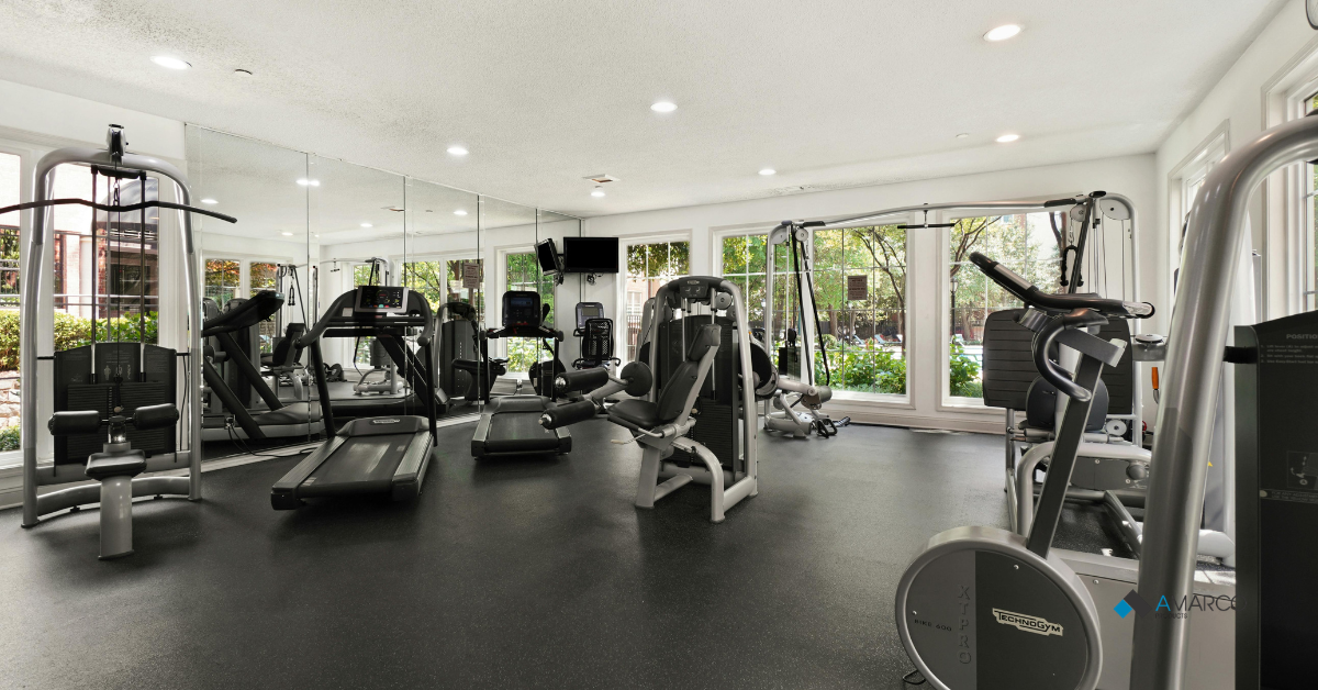 A modern commercial fitness center equipped with various exercise machines on protective rubber gym flooring thickness.